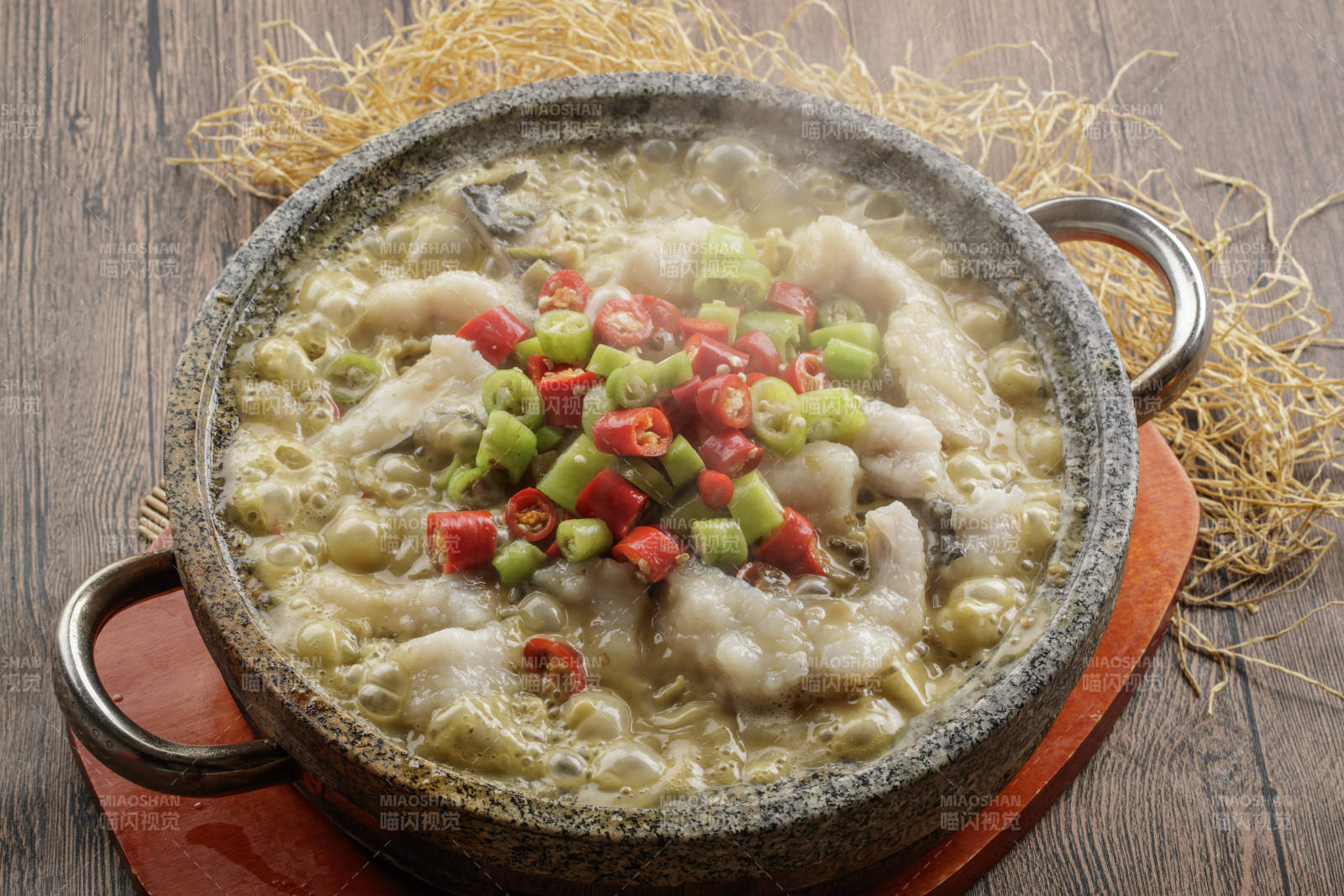 红木托盘上的石锅装的湘味沸腾鱼图片