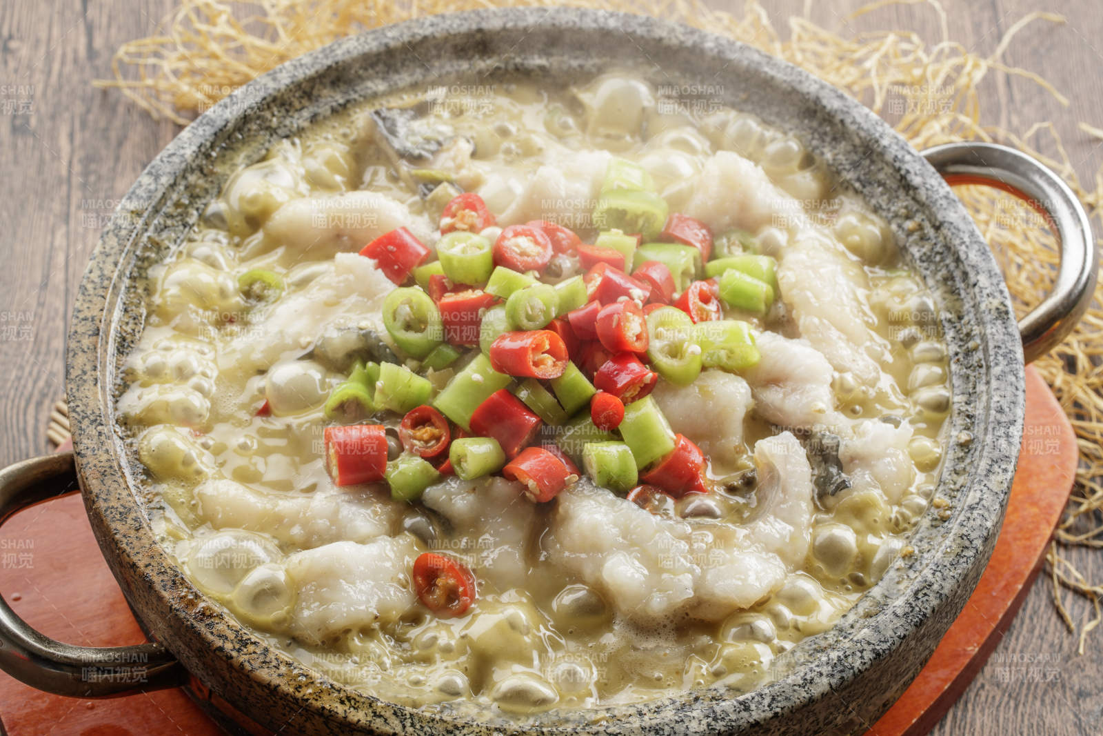 红木托盘上的石锅装的湘味沸腾鱼图片