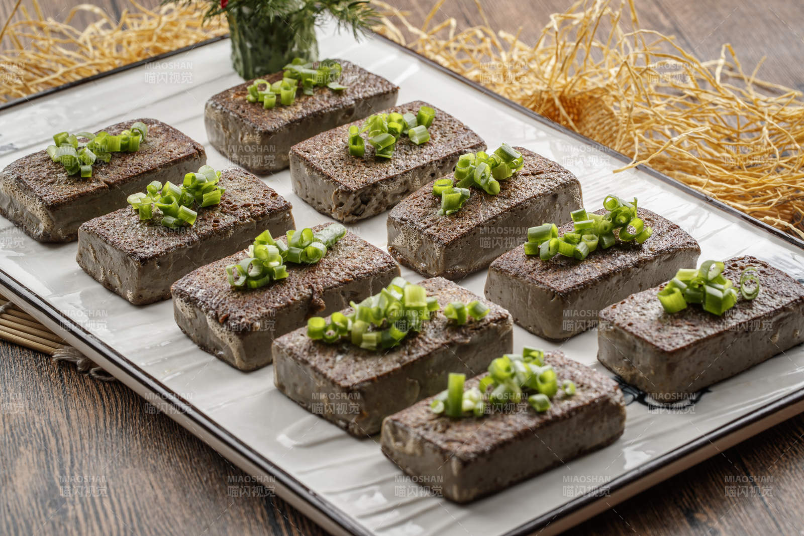 木纹底板上的长瓷盘装的香煎麻豆腐图片