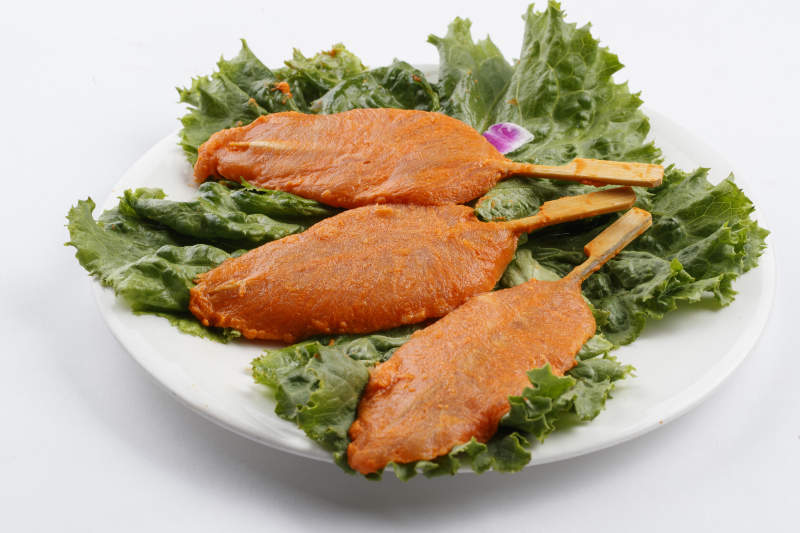 圆形白瓷盘装的腌制鸡胸串图片