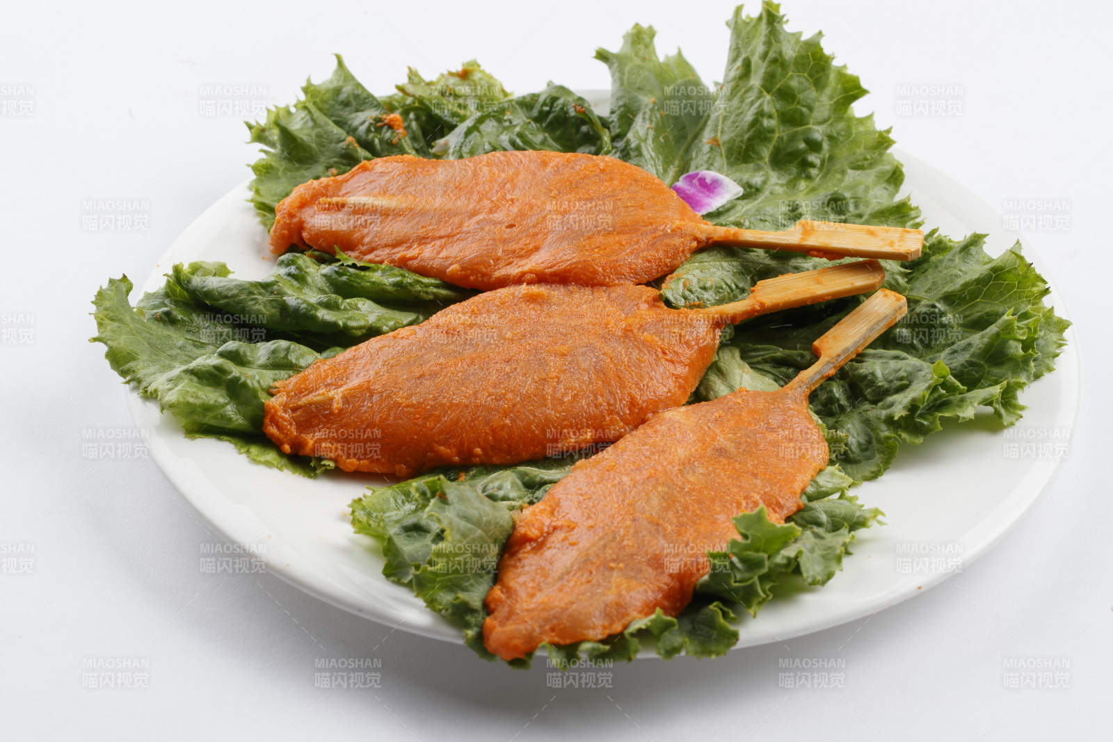 圆形白瓷盘装的腌制鸡胸串图片