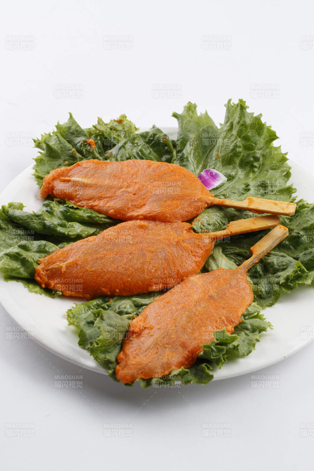 圆形白瓷盘装的腌制鸡胸串图片