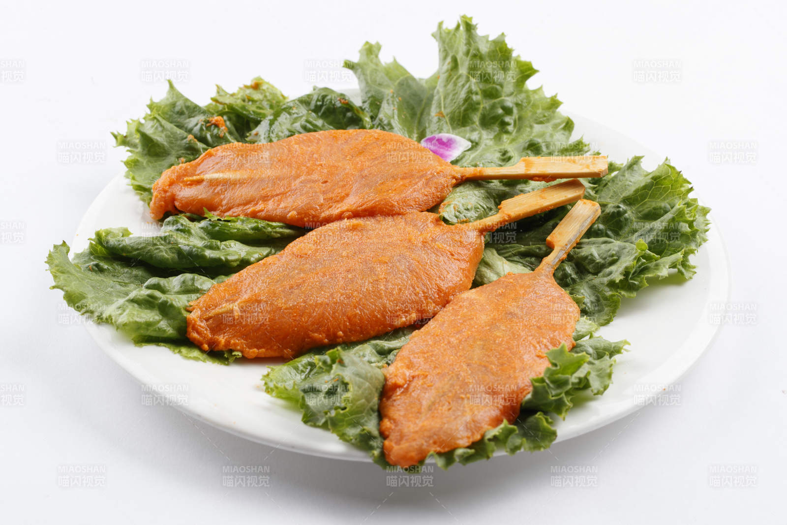 圆形白瓷盘装的腌制鸡胸串图片