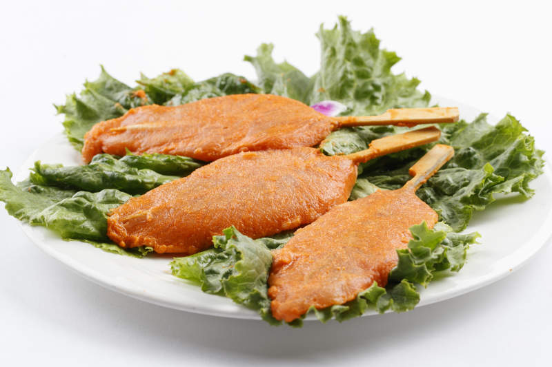 圆形白瓷盘装的腌制鸡胸串图片