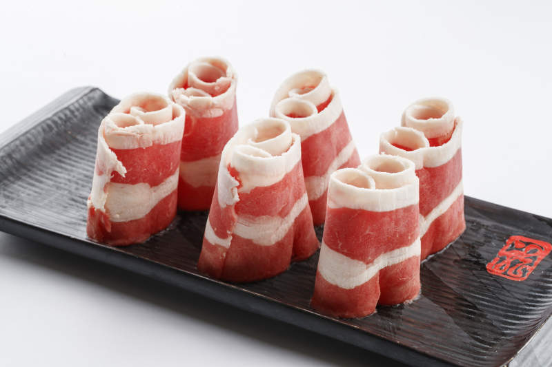 长方形黑色瓷盘装的羊五花卷图片