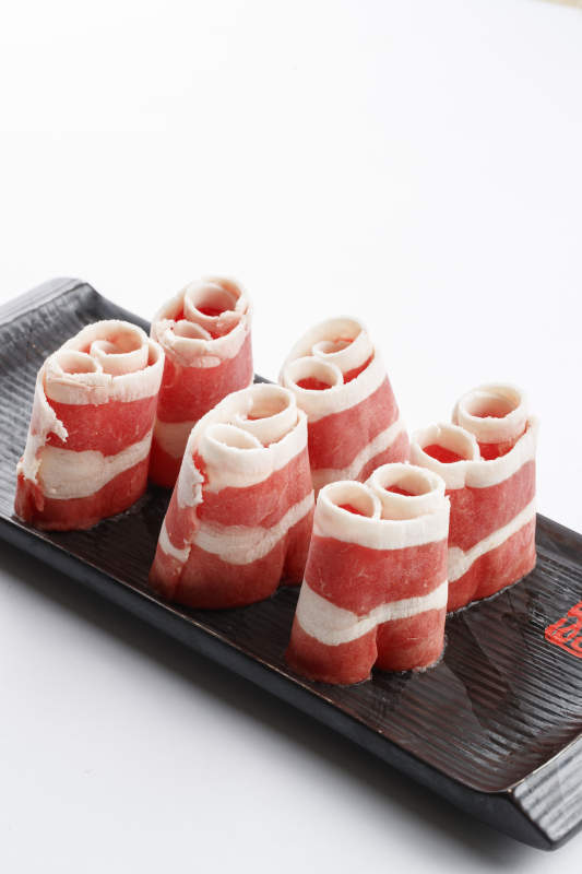 长方形黑色瓷盘装的羊五花卷图片