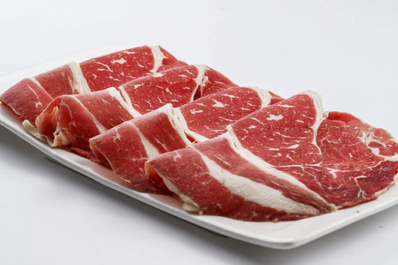 长方形白瓷盘装的牛肉片图片