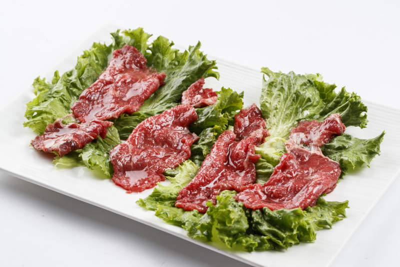 长方形白瓷盘装的鲜切牛里脊肉图片