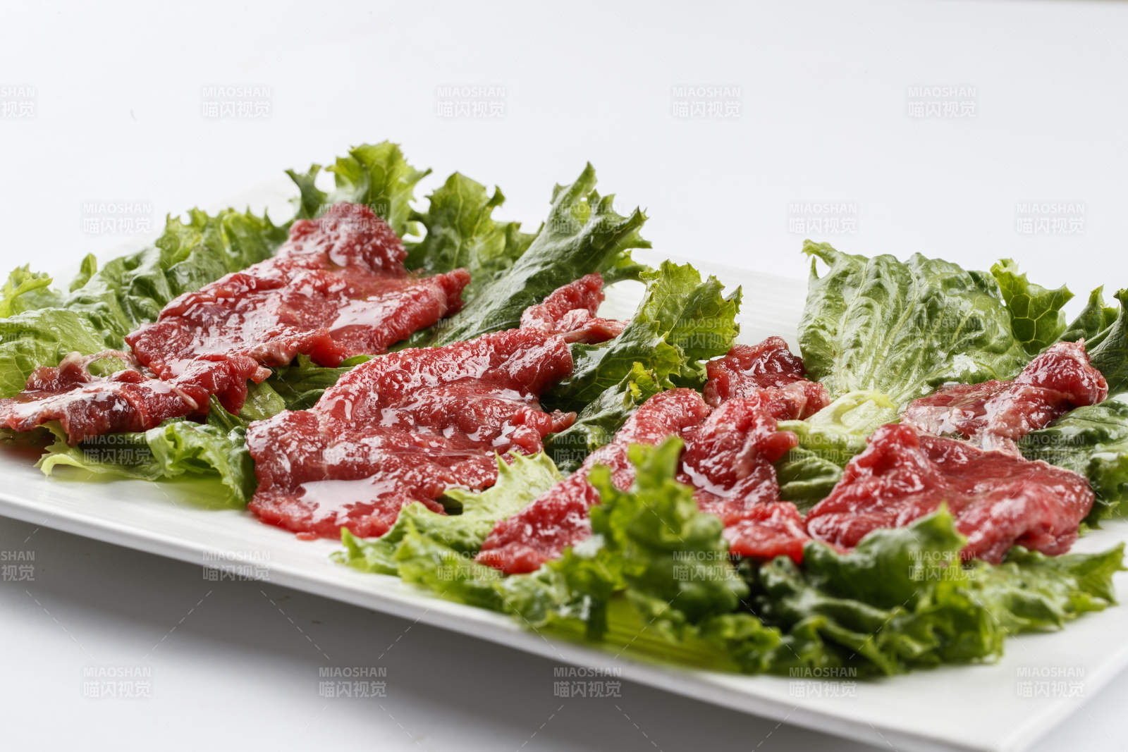 长方形白瓷盘装的鲜切牛里脊肉图片