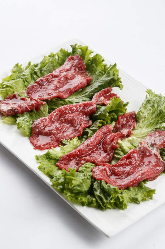 长方形白瓷盘装的鲜切牛里脊肉图片