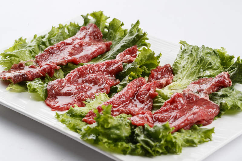 长方形白瓷盘装的鲜切牛里脊肉图片