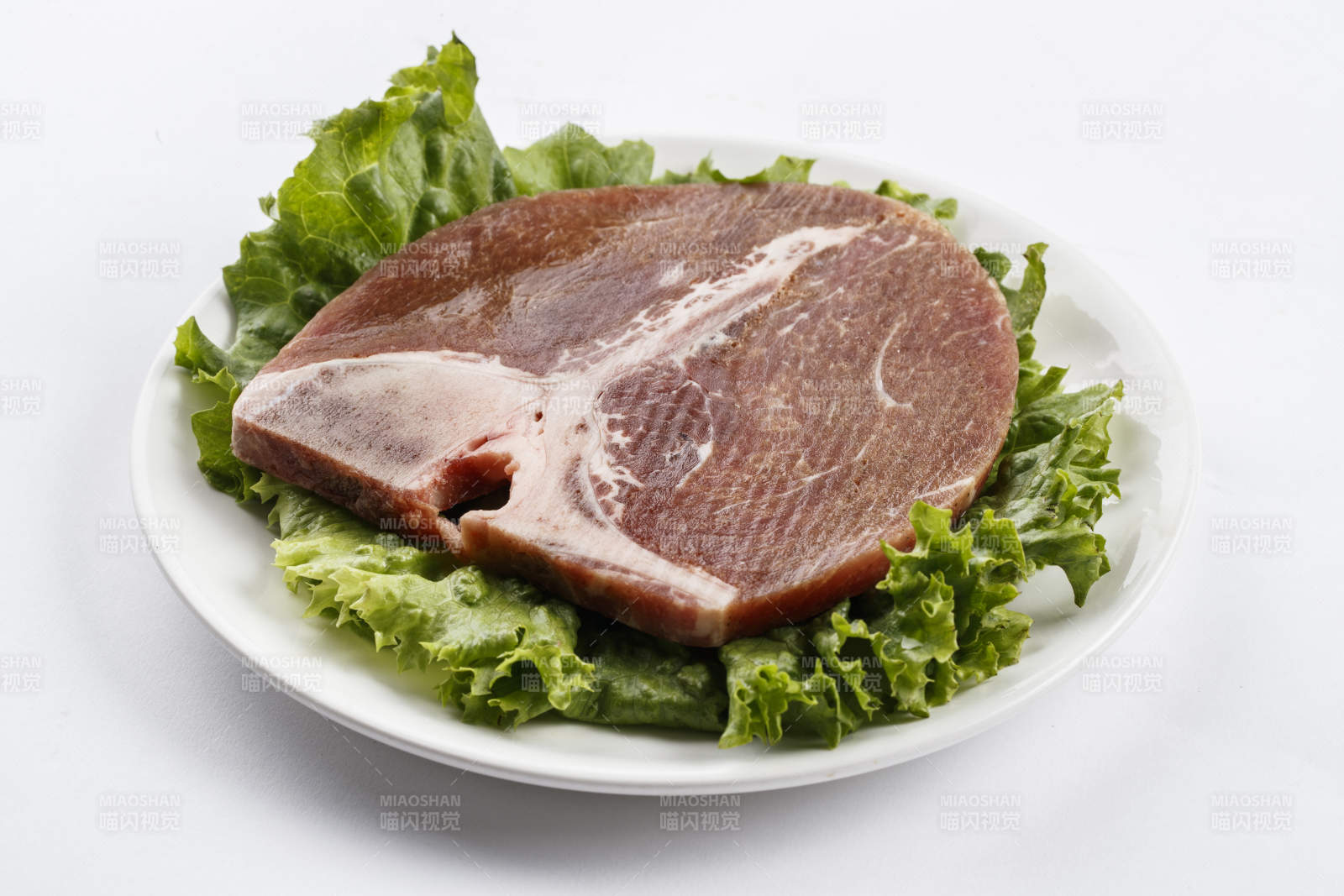 圆形白色瓷盘装的T骨牛排图片