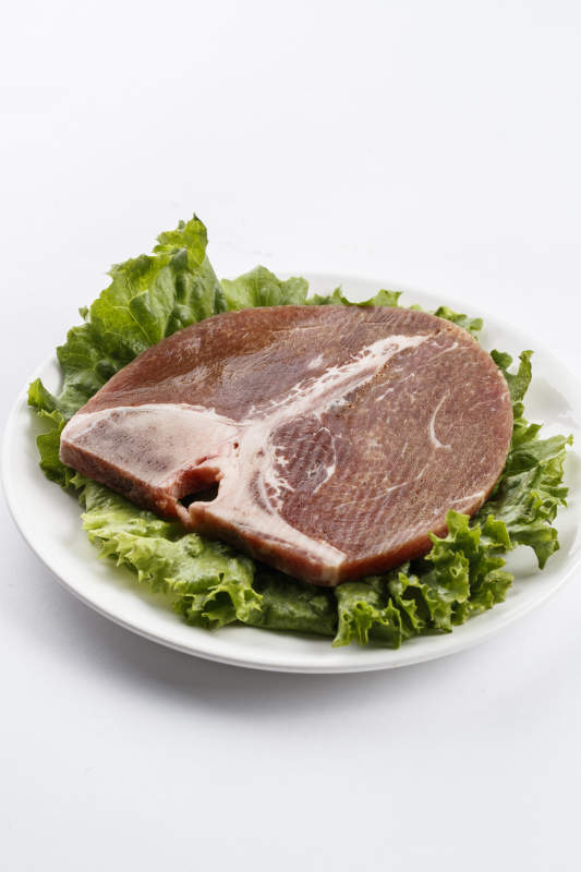 圆形白色瓷盘装的T骨牛排图片