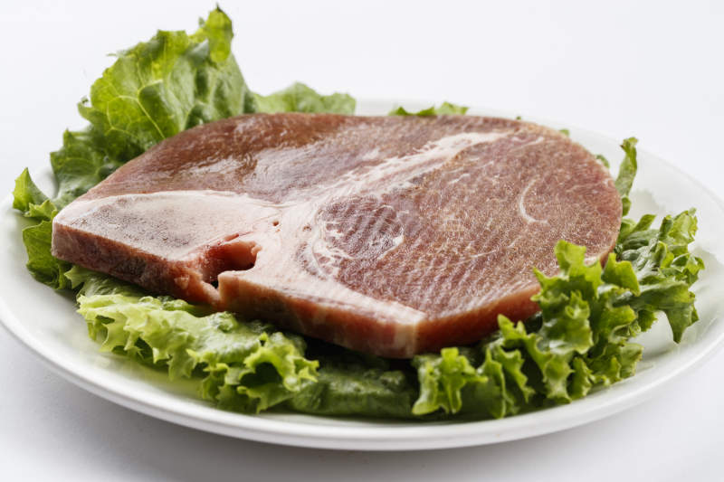 圆形白色瓷盘装的T骨牛排图片