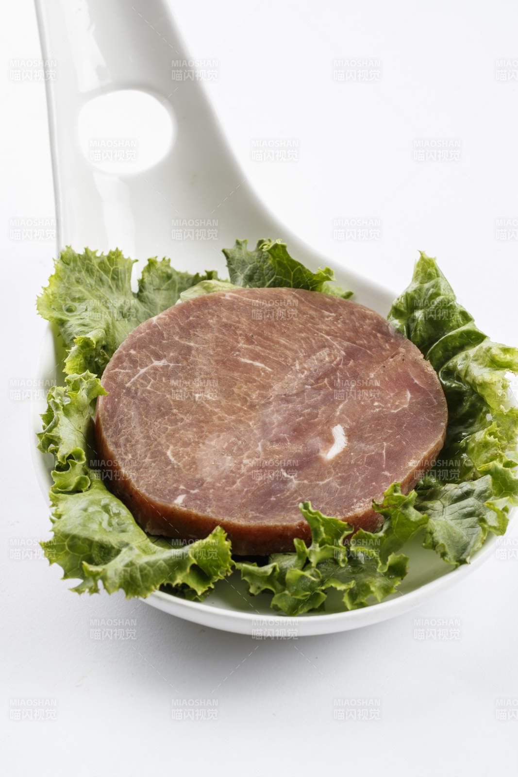 勺型瓷盘装的腌制牛排图片