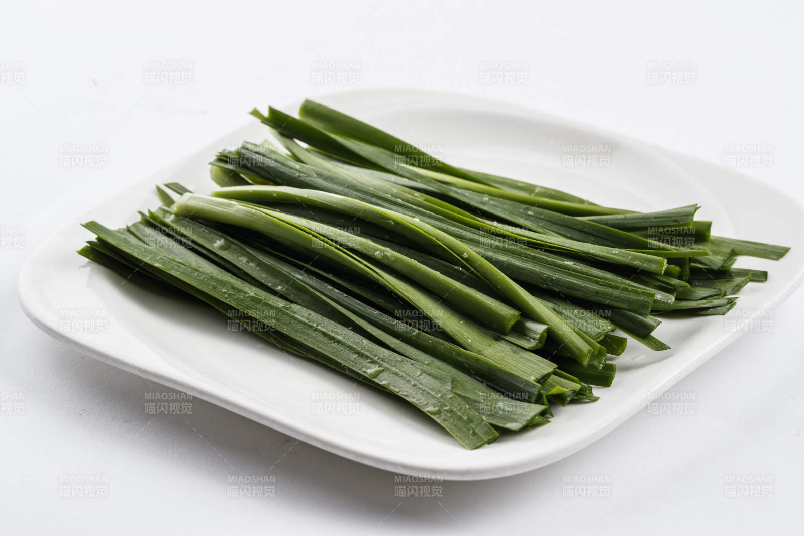 长方形白瓷盘装的鲜韭菜图片