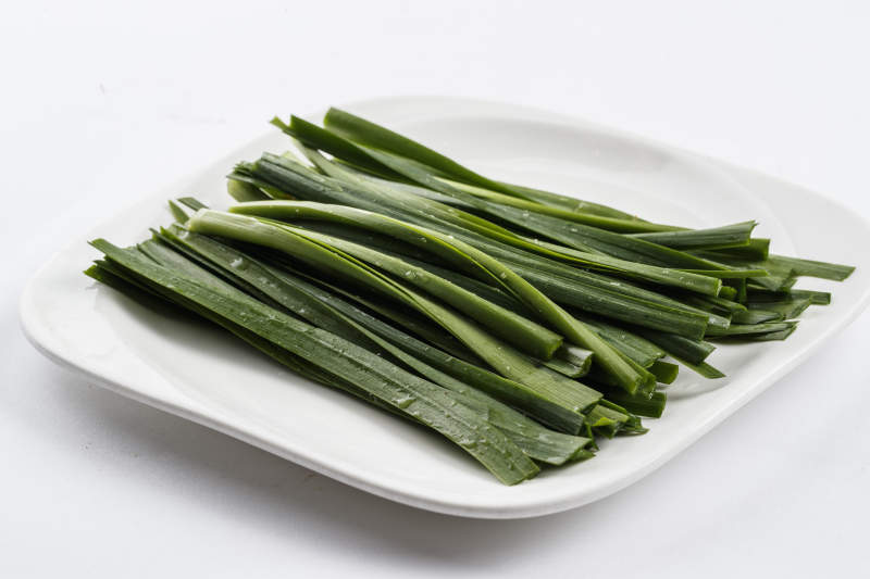 长方形白瓷盘装的鲜韭菜图片