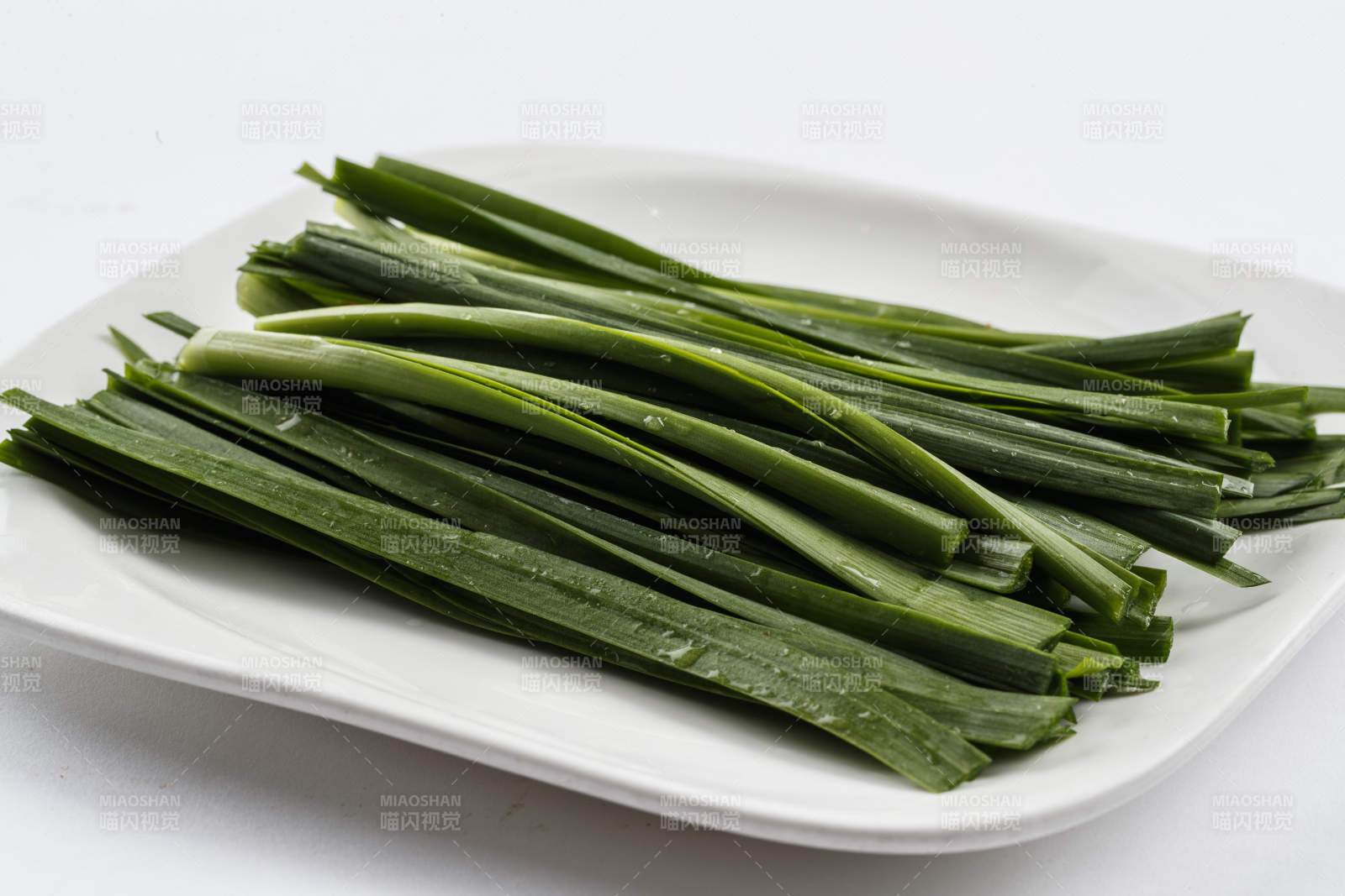 长方形白瓷盘装的鲜韭菜图片