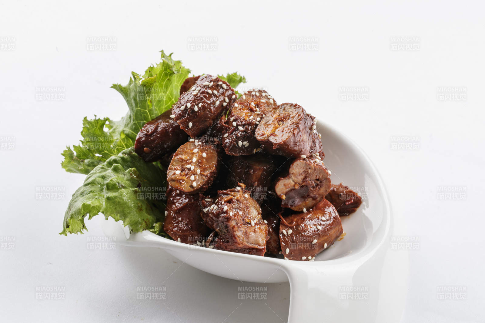 勺型白瓷盘装的麻辣鸭脖图片