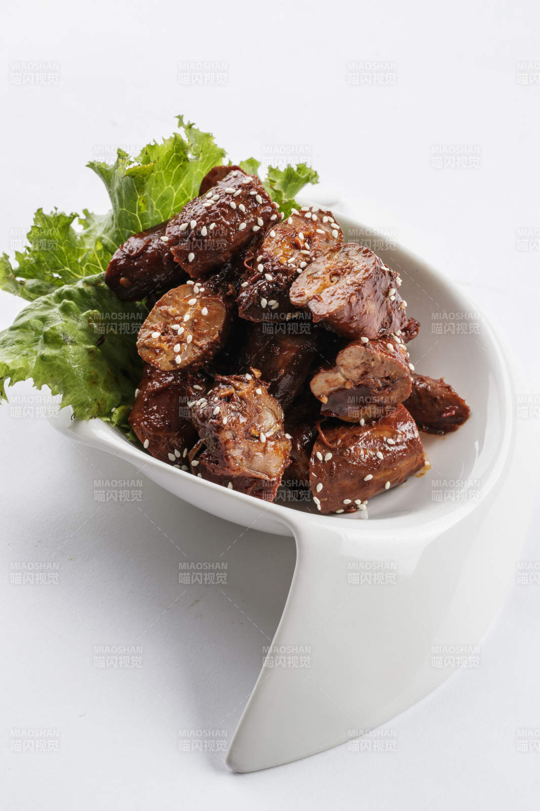 勺型白瓷盘装的麻辣鸭脖图片