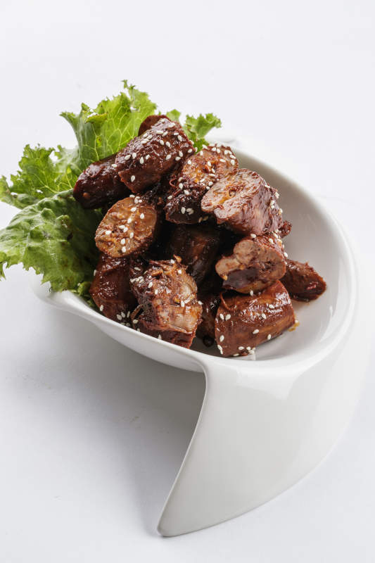 勺型白瓷盘装的麻辣鸭脖图片