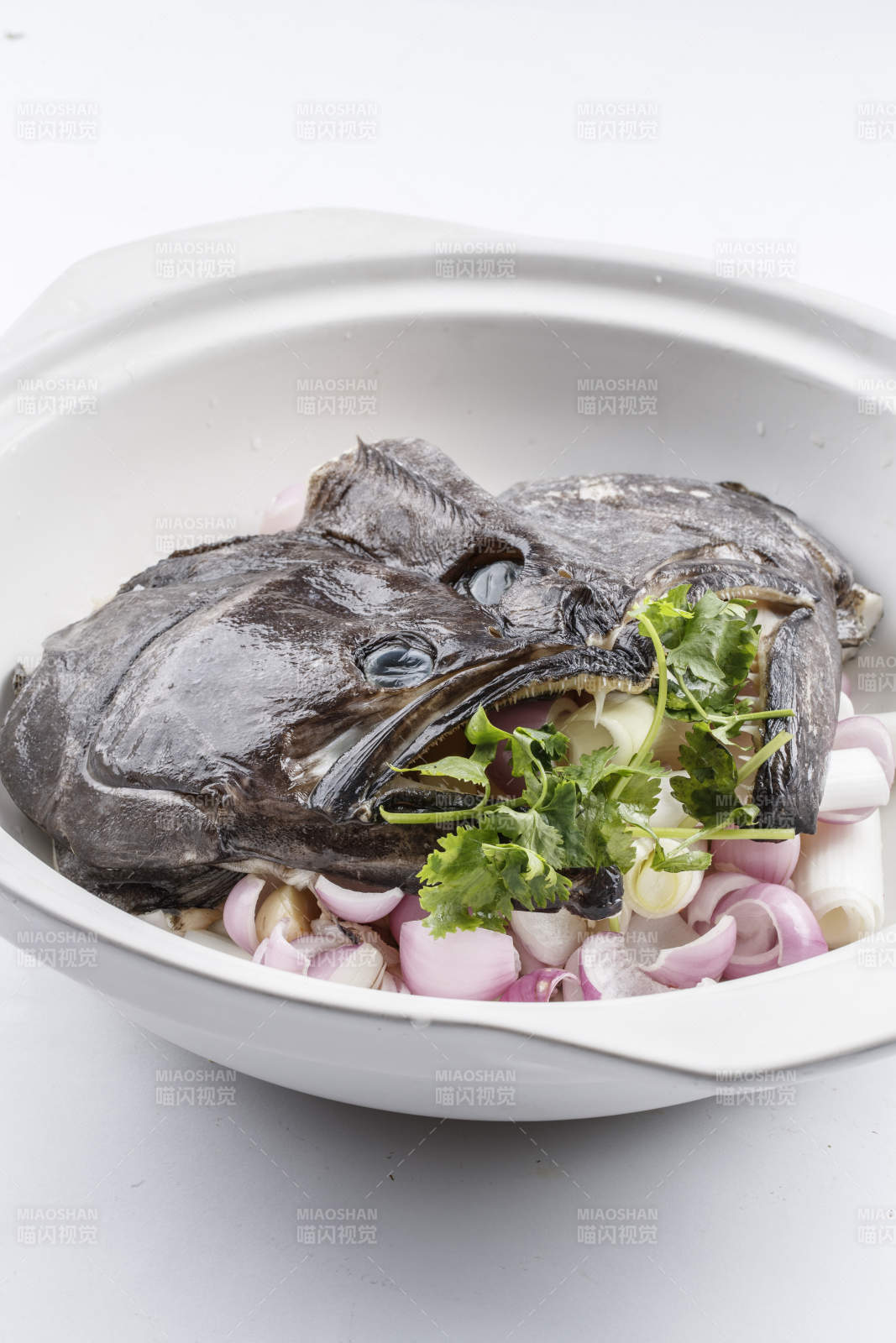 陈旧木板上的黑色砂锅装的浓汤生噘鲽鱼图片