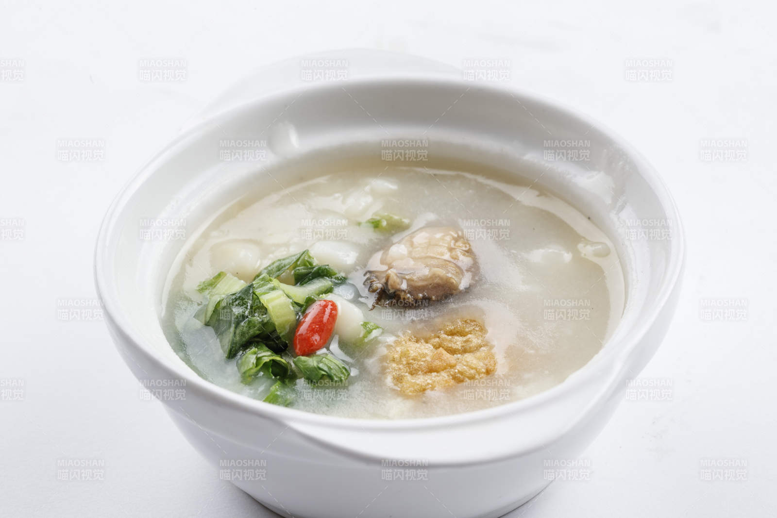 白色瓷碗装的鲜鲍鱼小白菜粥图片