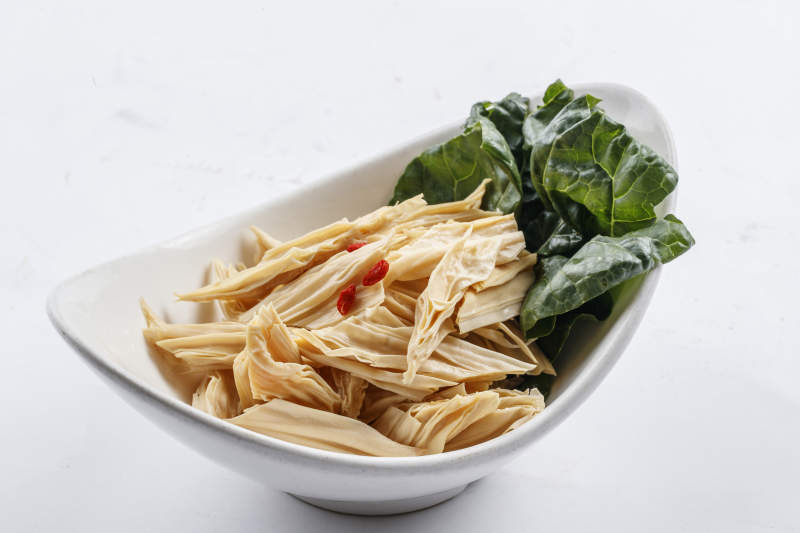 白色瓷盘装的火锅食材腐竹段图片