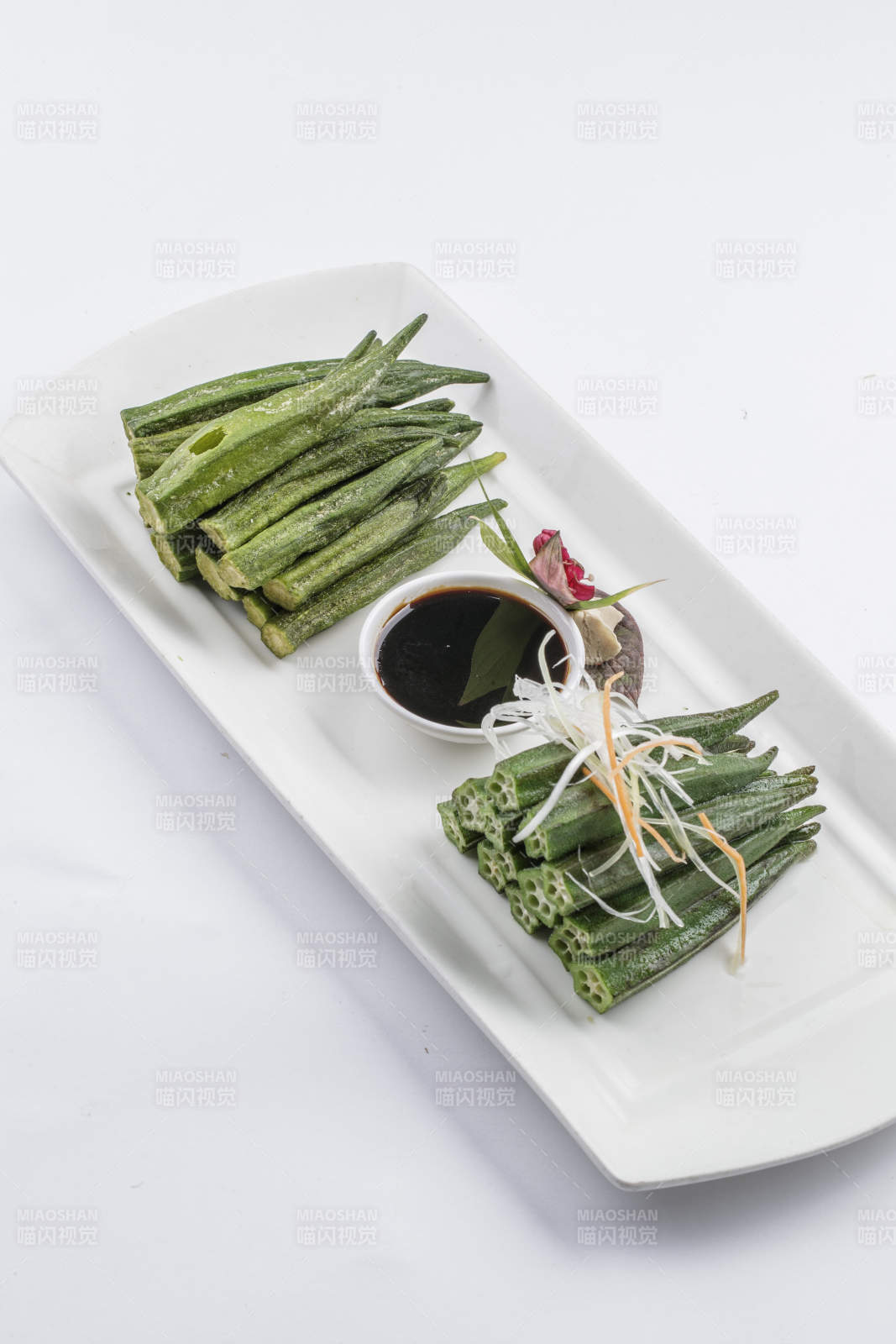 白色瓷盘装的浇汁鲜秋葵图片