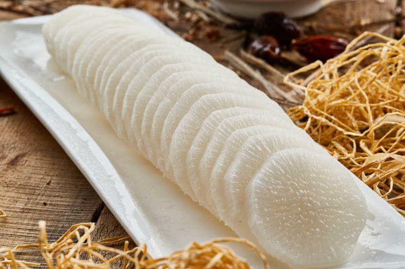 白色长瓷盘装的白萝卜片火锅涮菜图片
