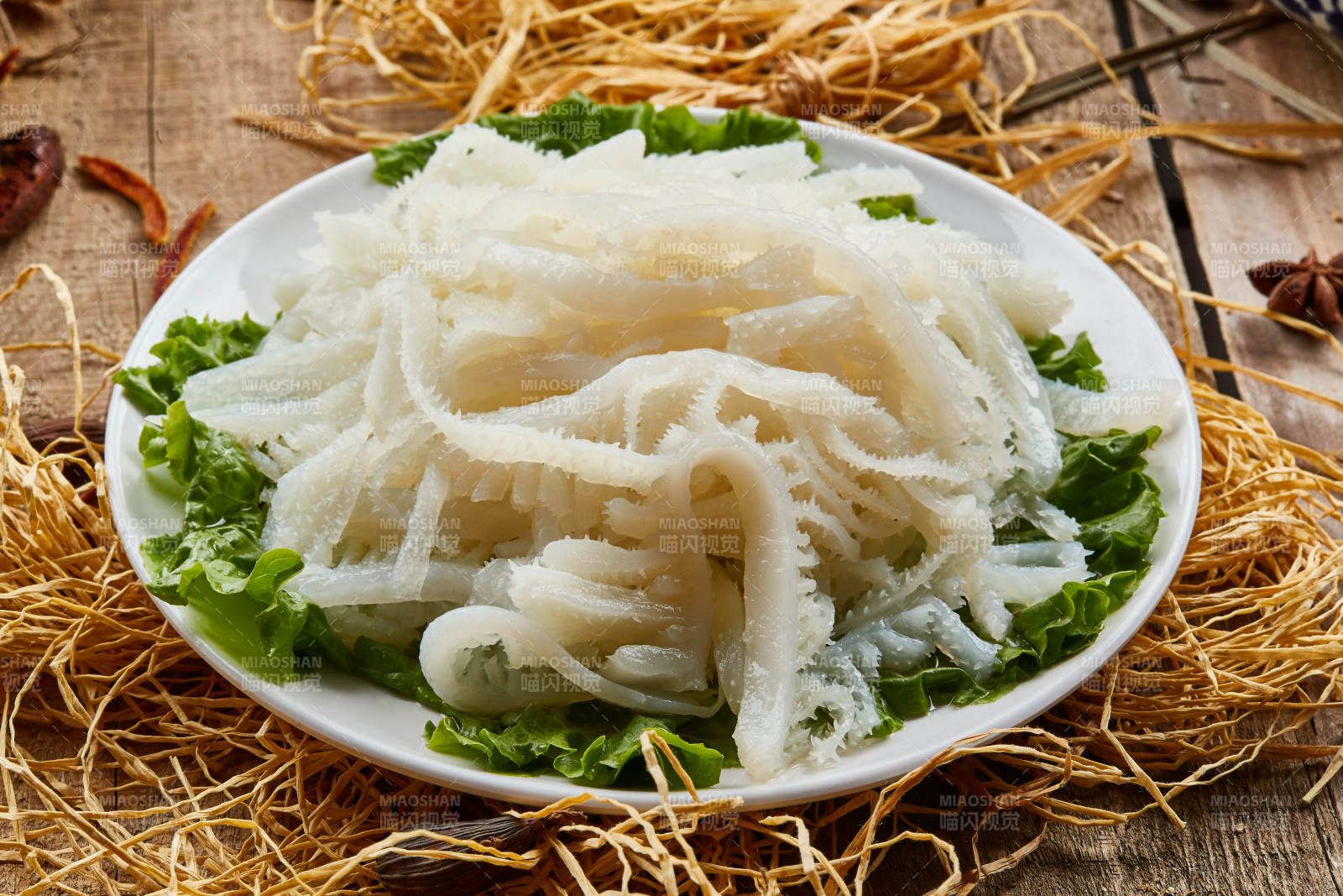 白色圆瓷盘装的金钱肚火锅涮菜图片