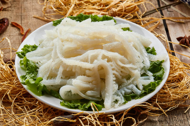 白色圆瓷盘装的金钱肚火锅涮菜图片