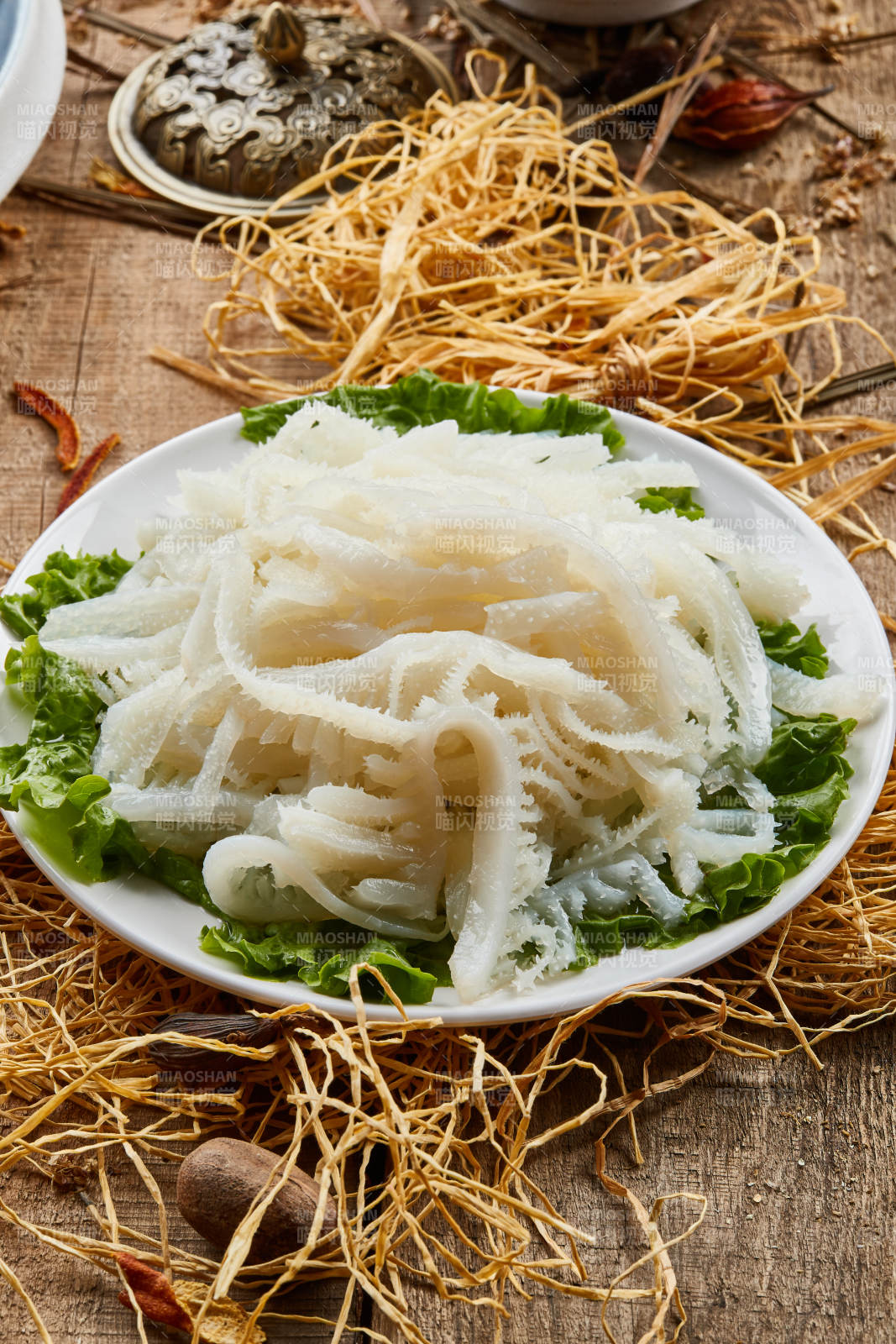 白色圆瓷盘装的金钱肚火锅涮菜图片