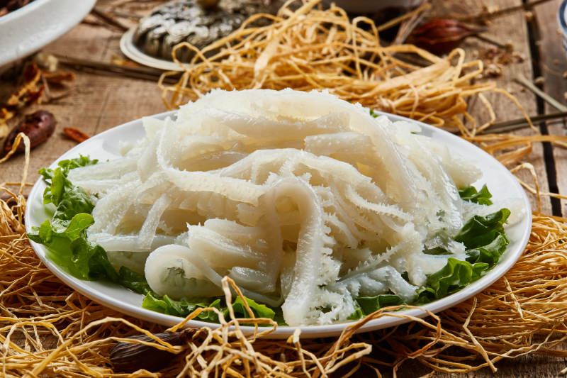 白色圆瓷盘装的金钱肚火锅涮菜图片