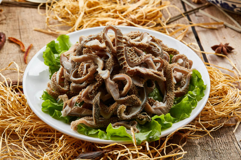 白色圆瓷盘装的羊肚仁儿火锅涮菜图片