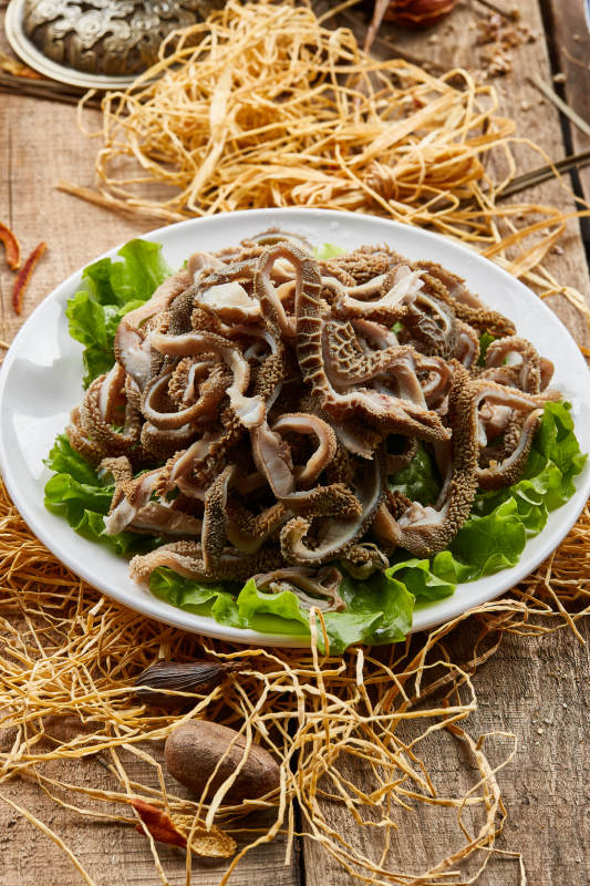 白色圆瓷盘装的羊肚仁儿火锅涮菜图片