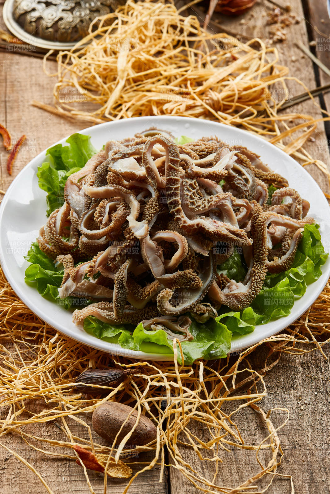 白色圆瓷盘装的羊肚仁儿火锅涮菜图片