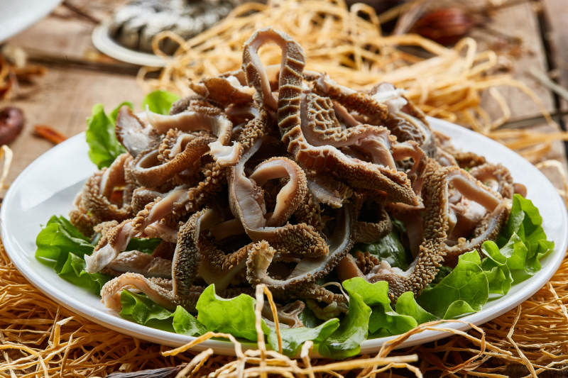 白色圆瓷盘装的羊肚仁儿火锅涮菜图片