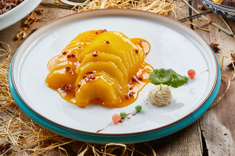 双色圆瓷盘装的沙棘雪梨图片