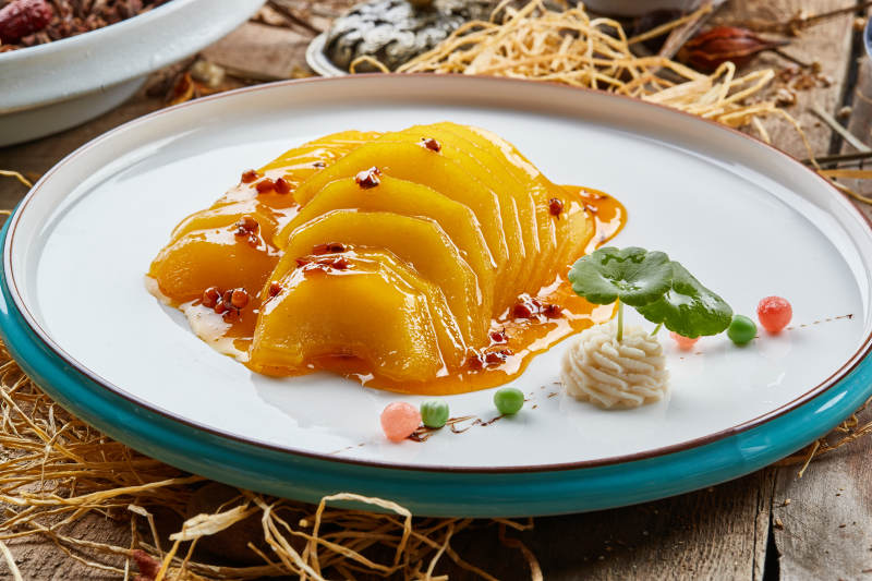 双色圆瓷盘装的沙棘雪梨图片