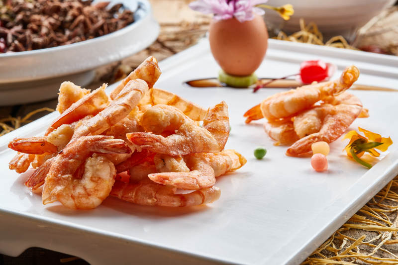 黑色瓷盘装的避风塘炸虾图片