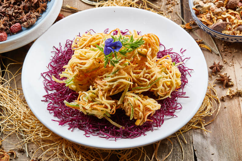 圆形白瓷盘装的香炸什锦蔬菜丝图片