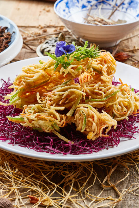 圆形白瓷盘装的香炸什锦蔬菜丝图片