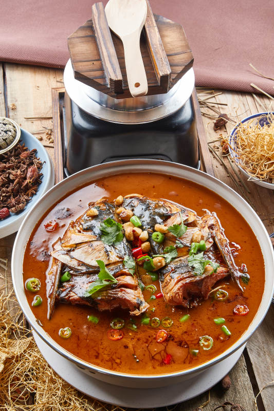 大型器皿装的家炖野生大鱼头配米饭图片