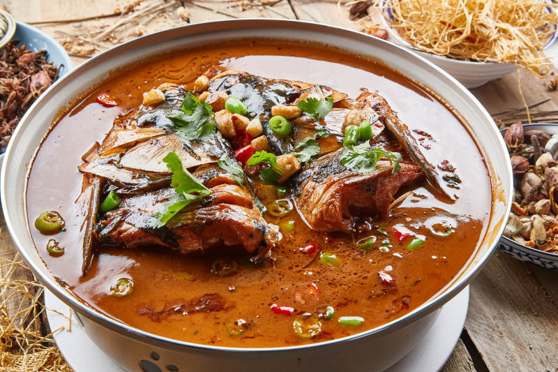 大型器皿装的家炖野生大鱼头配米饭图片