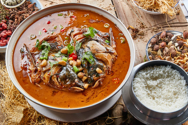 大型器皿装的家炖野生大鱼头配米饭图片