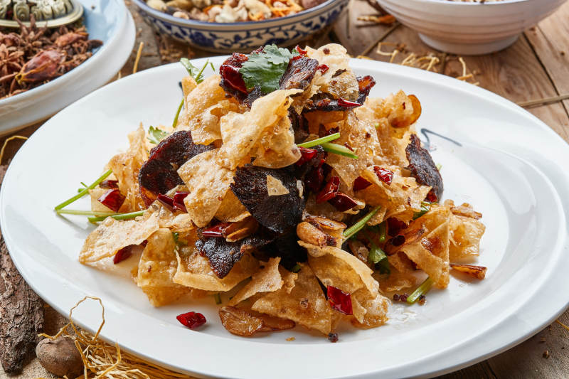 白色瓷盘装的干炸牛肉拌薯片图片
