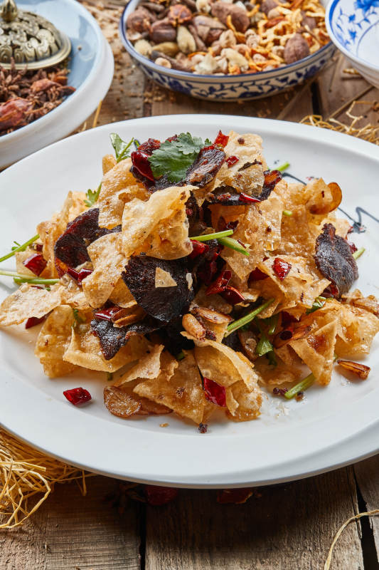 白色瓷盘装的干炸牛肉拌薯片图片