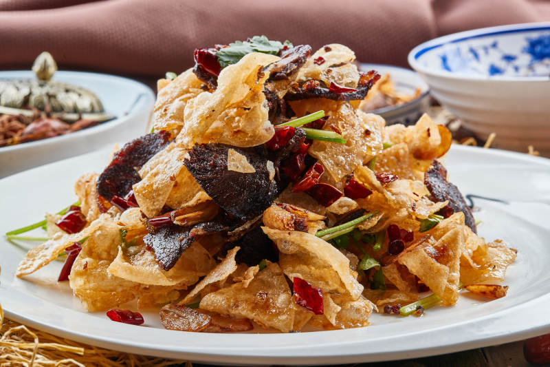 白色瓷盘装的干炸牛肉拌薯片图片