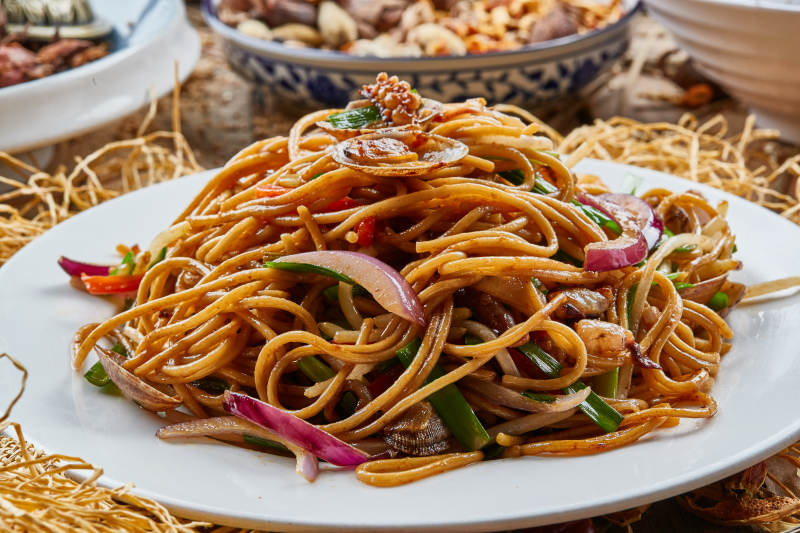 青瓷盘装的海鲜炒意大利面图片